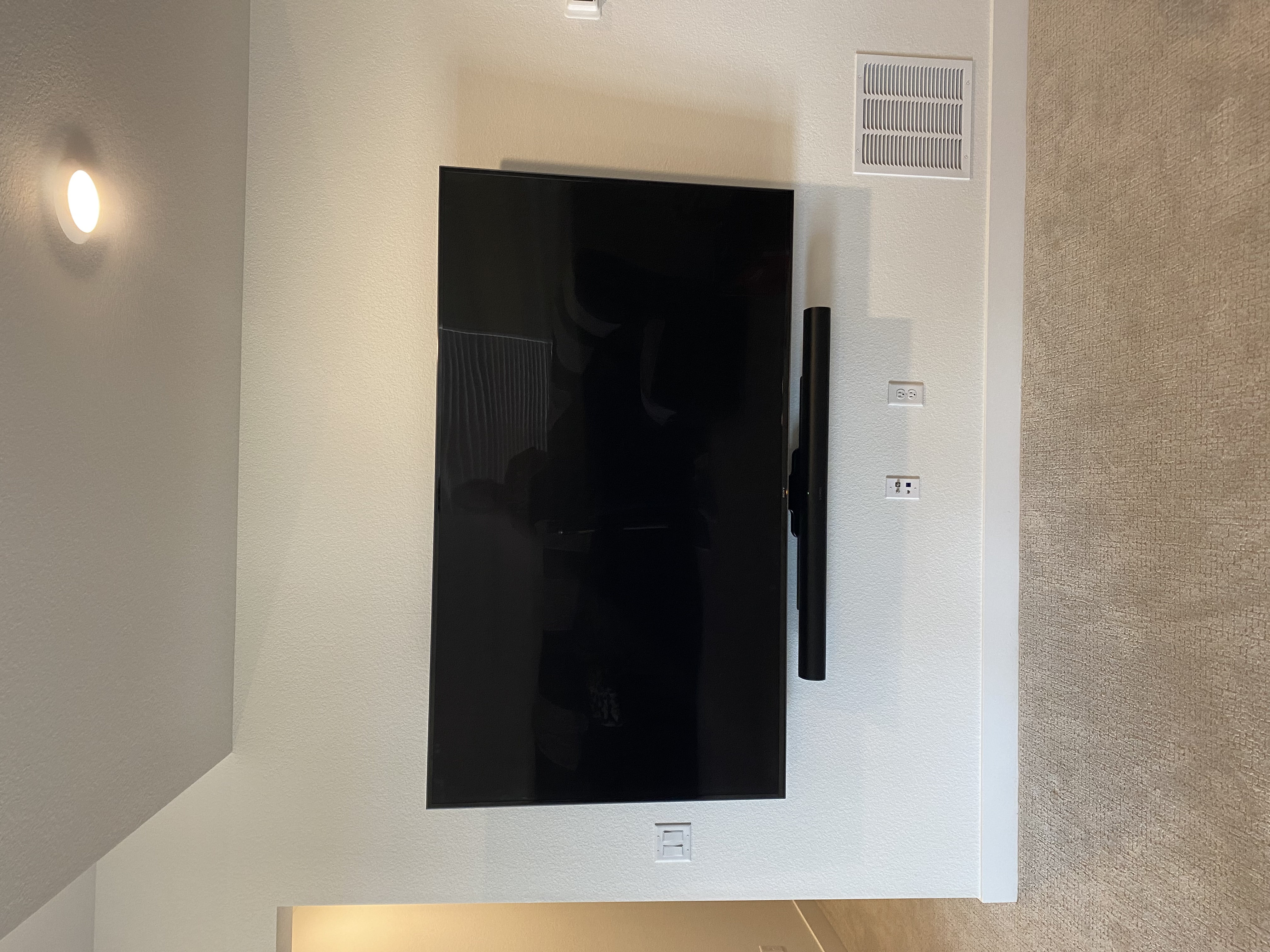 Clean TV wall mount with soundbar on white wall